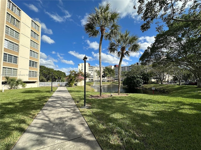 view of community with a water view and a lawn