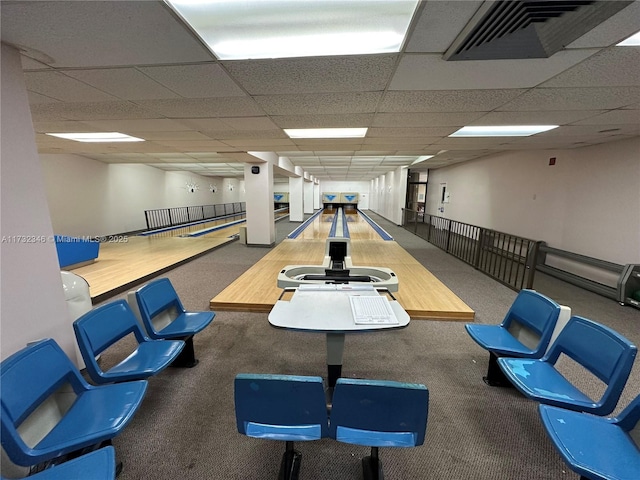 interior space with carpet flooring, bowling, and a drop ceiling