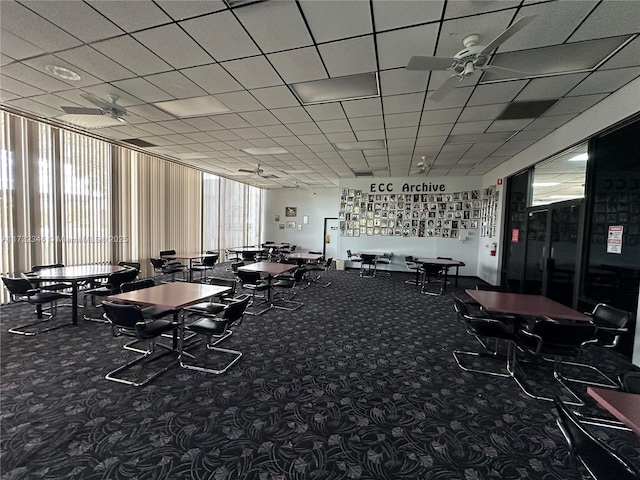 workout area featuring ceiling fan, carpet, and a drop ceiling