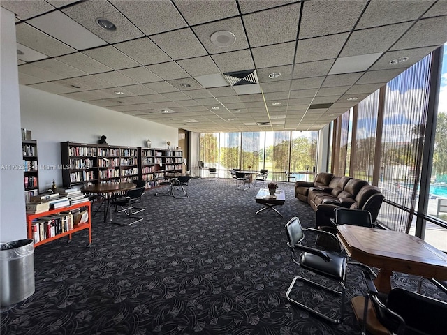 interior space featuring carpet floors, expansive windows, and a paneled ceiling