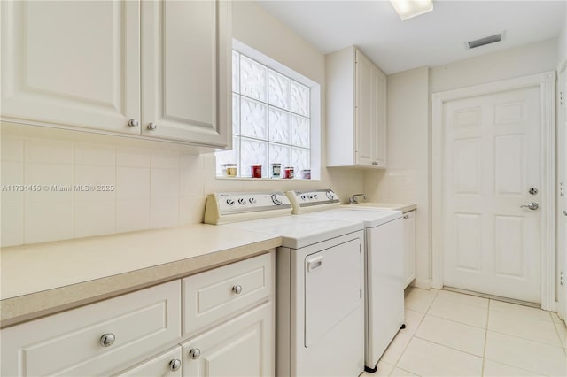 laundry area featuring sink, cabinets, light tile patterned floors, and washer and dryer