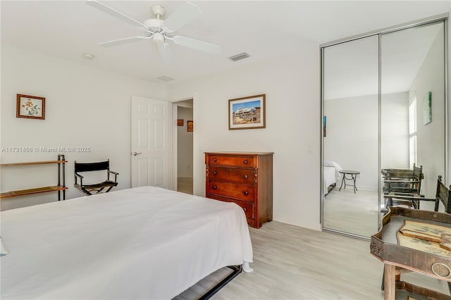 bedroom featuring light wood-type flooring, ceiling fan, and a closet