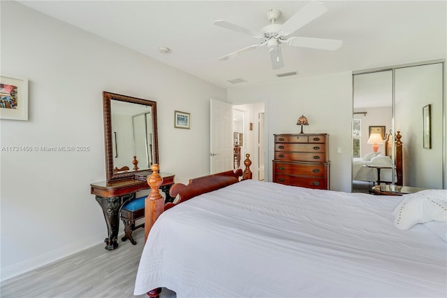 bedroom featuring ceiling fan, a closet, and light wood-type flooring