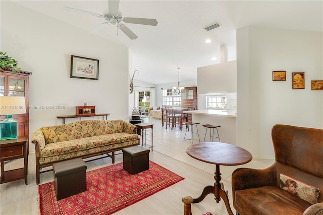 living room with light tile patterned flooring, lofted ceiling, and ceiling fan with notable chandelier