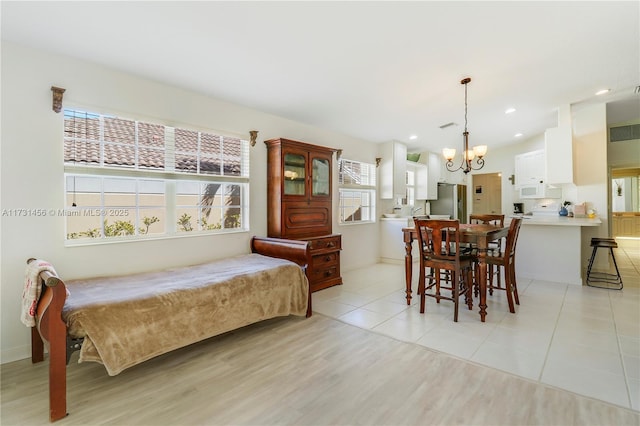 bedroom with stainless steel refrigerator, light tile patterned floors, and a notable chandelier