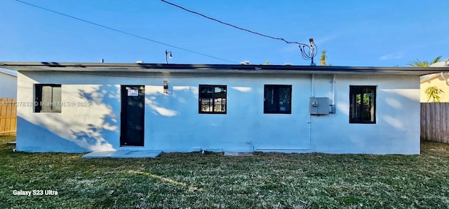 rear view of house featuring a yard