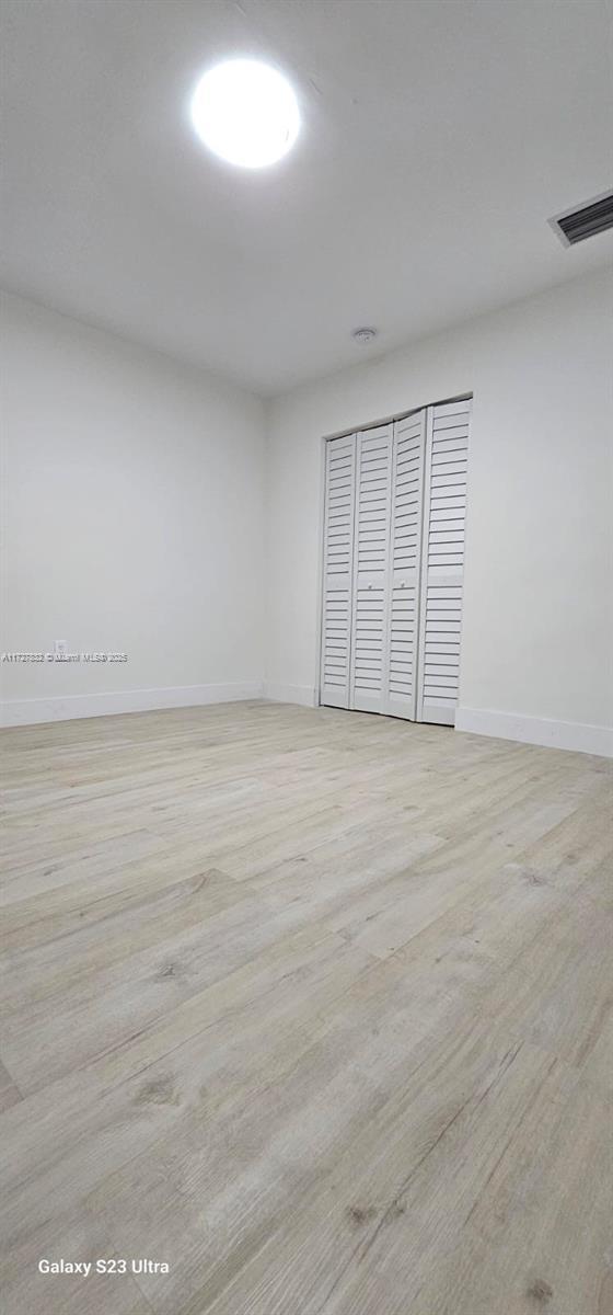 empty room with light hardwood / wood-style flooring