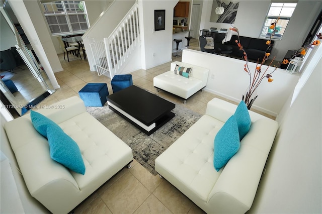 living area featuring stairs and light tile patterned floors