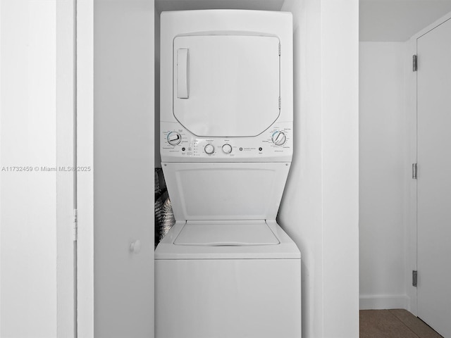 washroom featuring stacked washing maching and dryer and tile patterned flooring