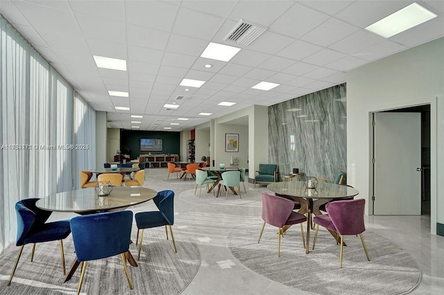 dining space with a drop ceiling