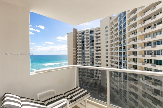 balcony featuring a water view and a view of the beach