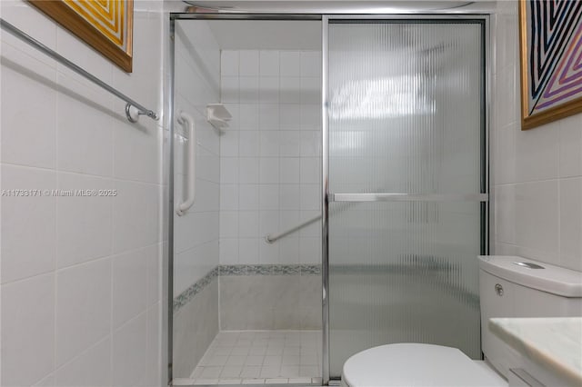 bathroom featuring a shower with door and toilet