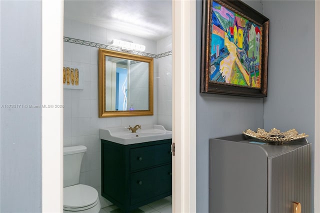 bathroom with vanity, tile walls, and toilet