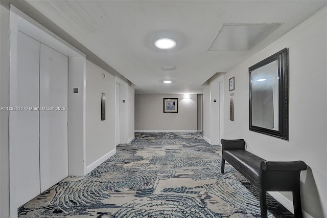 corridor with elevator and carpet