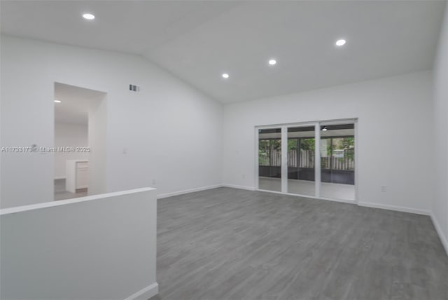 empty room with lofted ceiling and hardwood / wood-style floors