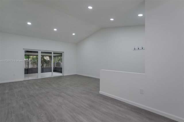 spare room featuring vaulted ceiling and hardwood / wood-style floors