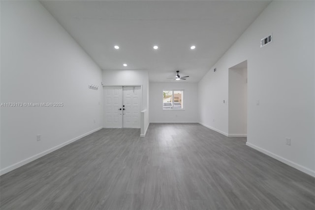 empty room featuring vaulted ceiling, dark hardwood / wood-style floors, and ceiling fan