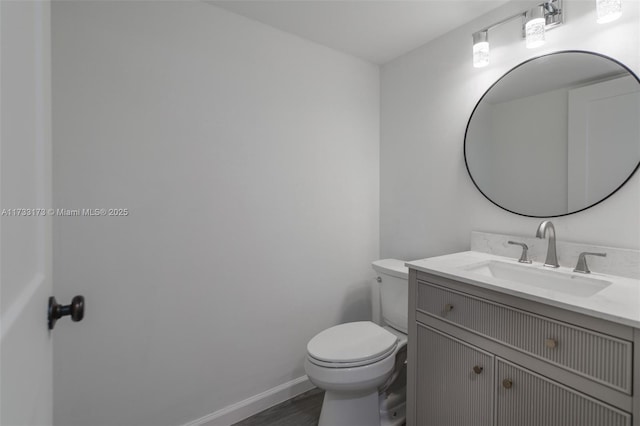 bathroom featuring vanity, hardwood / wood-style flooring, and toilet