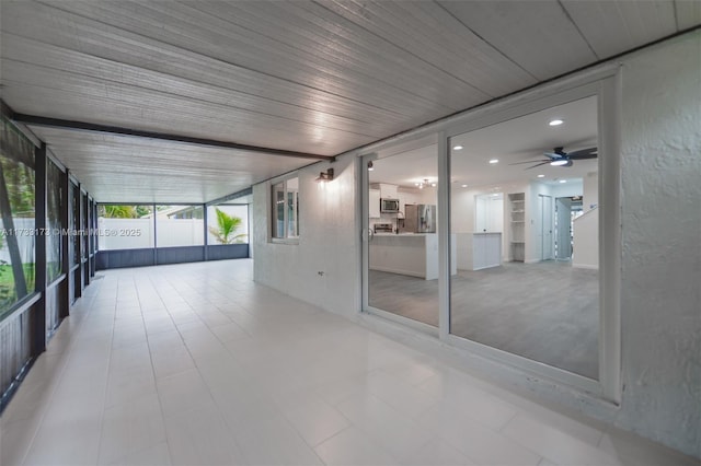 unfurnished sunroom with wooden ceiling and ceiling fan