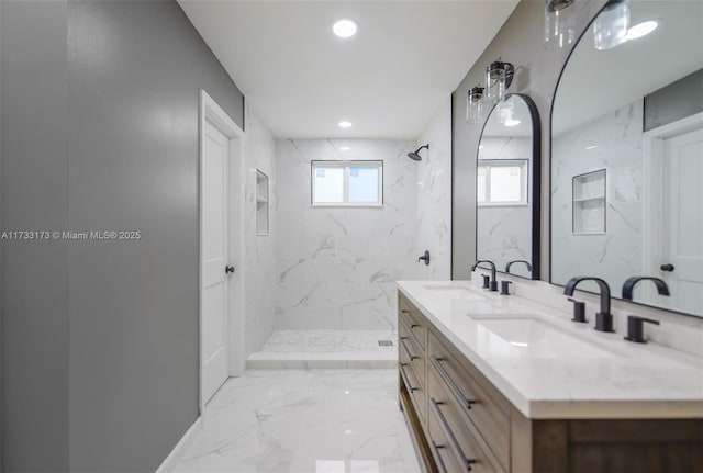 bathroom featuring tiled shower and vanity