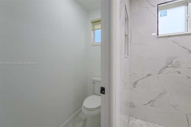 bathroom with a shower, a wealth of natural light, and toilet