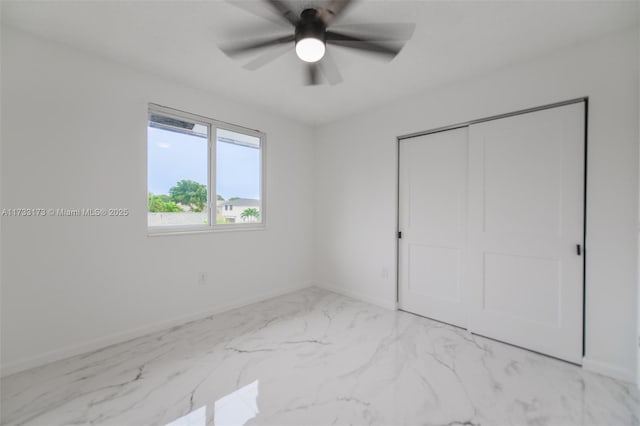 unfurnished bedroom with ceiling fan and a closet