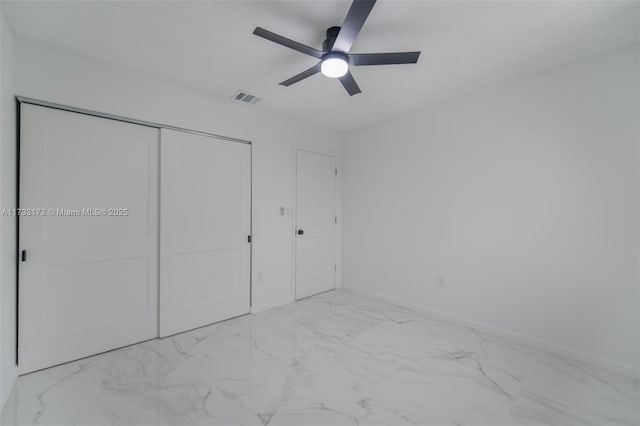 unfurnished bedroom with ceiling fan and a closet