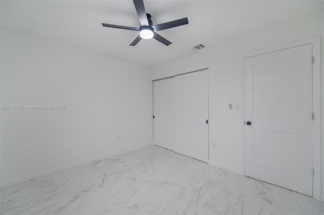 unfurnished bedroom featuring ceiling fan and a closet