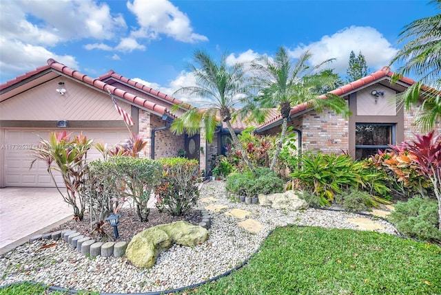 510 NW 105th Dr, Coral Springs, FL 33071 - mediterranean / spanish house with brick siding, a tiled roof, a garage, and decorative driveway