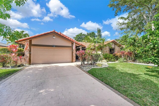 510 NW 105th Dr, Coral Springs, FL 33071 - view of front of house featuring stucco siding, decorative driveway, an attached garage, a front yard, and a tile roof