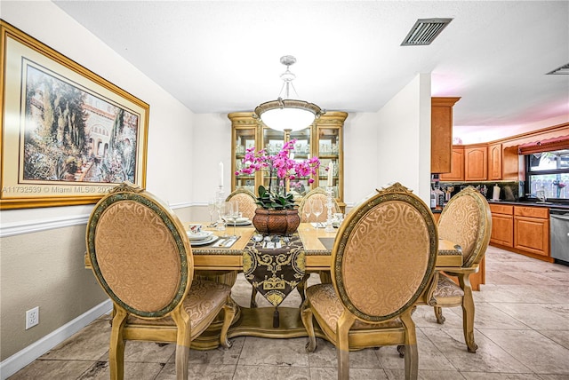 dining space featuring sink and light tile patterned floors