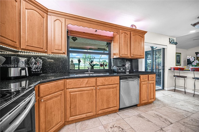 kitchen with dishwasher, sink, decorative backsplash, and dark stone countertops