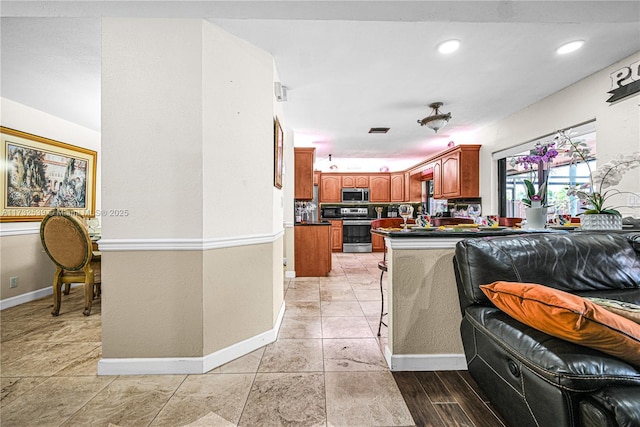 510 NW 105th Dr, Coral Springs, FL 33071 - kitchen featuring baseboards, dark countertops, visible vents, brown cabinetry, and appliances with stainless steel finishes