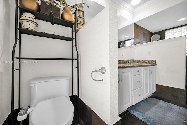 bathroom with vanity, crown molding, and toilet