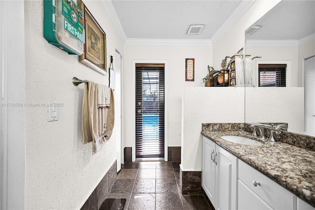 bathroom featuring ornamental molding, vanity, and a textured ceiling