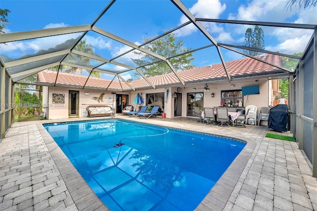 view of swimming pool featuring ceiling fan, grilling area, a lanai, and a patio