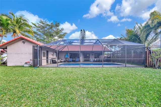 back of property featuring a yard and glass enclosure