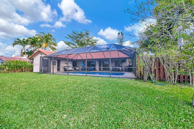 rear view of property with a yard and glass enclosure