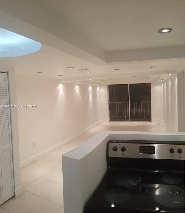 interior space with stainless steel electric range and light tile patterned floors