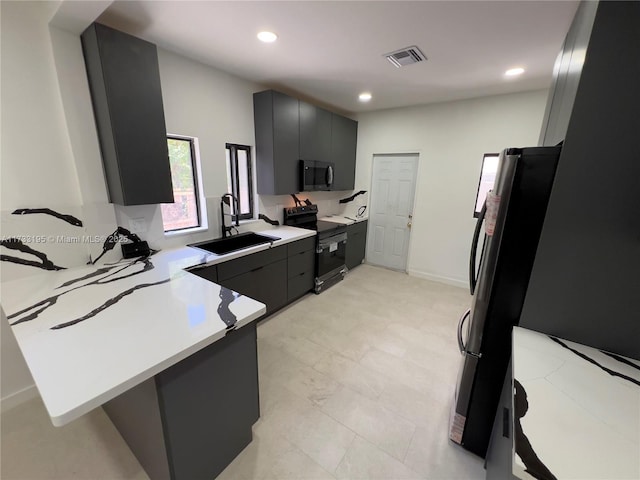 kitchen with stainless steel appliances, sink, a kitchen bar, and kitchen peninsula