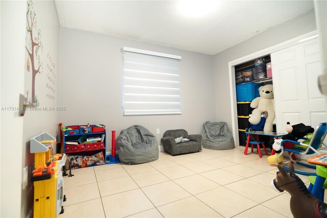 game room featuring a textured ceiling and light tile patterned flooring