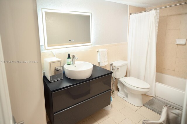 full bathroom with tile patterned floors, toilet, shower / tub combo, tile walls, and vanity