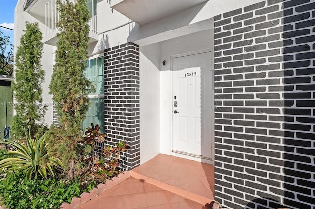 property entrance featuring brick siding