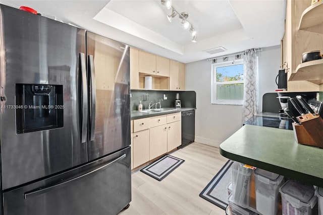 kitchen with light wood-style flooring, stainless steel refrigerator with ice dispenser, a sink, a tray ceiling, and dishwasher