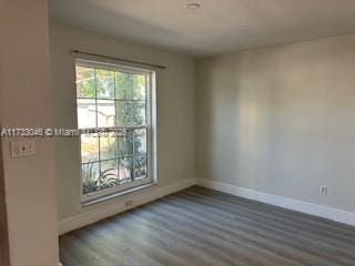 unfurnished room featuring baseboards and wood finished floors