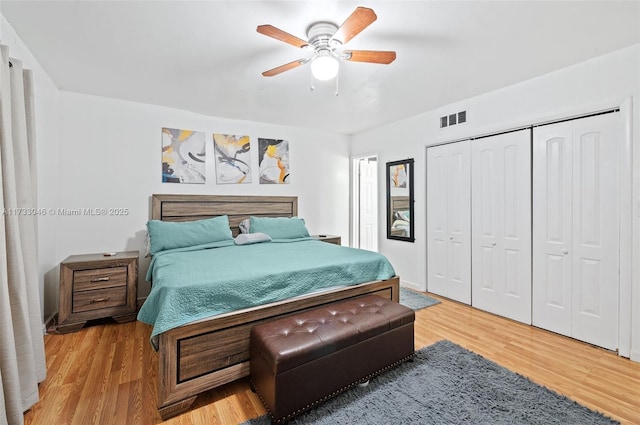 bedroom with a closet, visible vents, light wood finished floors, and ceiling fan