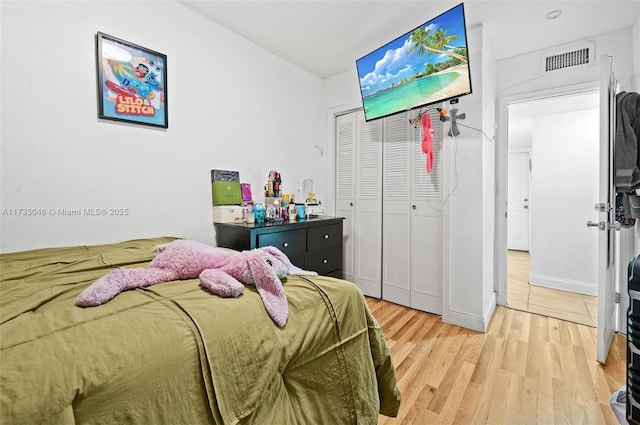 bedroom with visible vents, a closet, and light wood finished floors