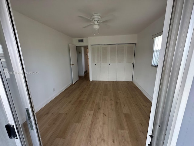 unfurnished bedroom featuring a closet, ceiling fan, and light wood-type flooring