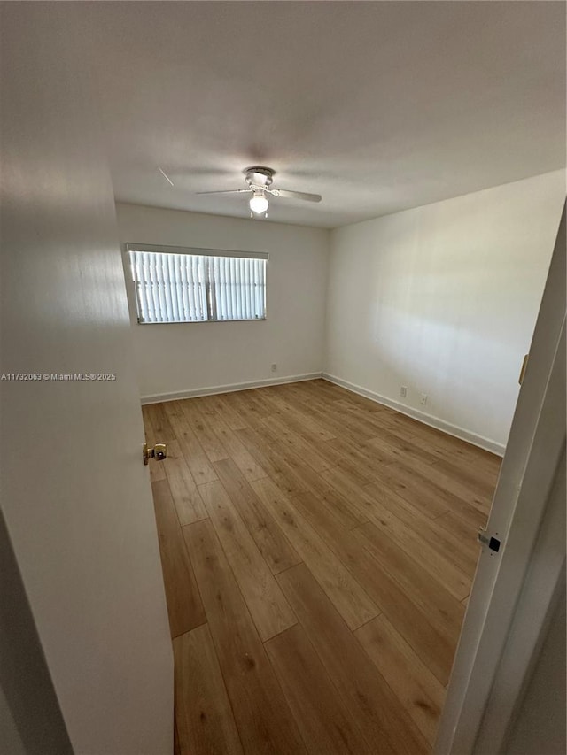 empty room with ceiling fan and light wood-type flooring