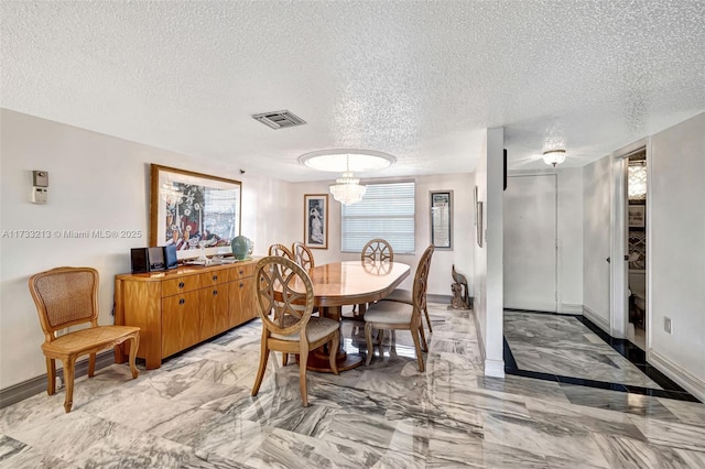 dining room with a notable chandelier and a textured ceiling